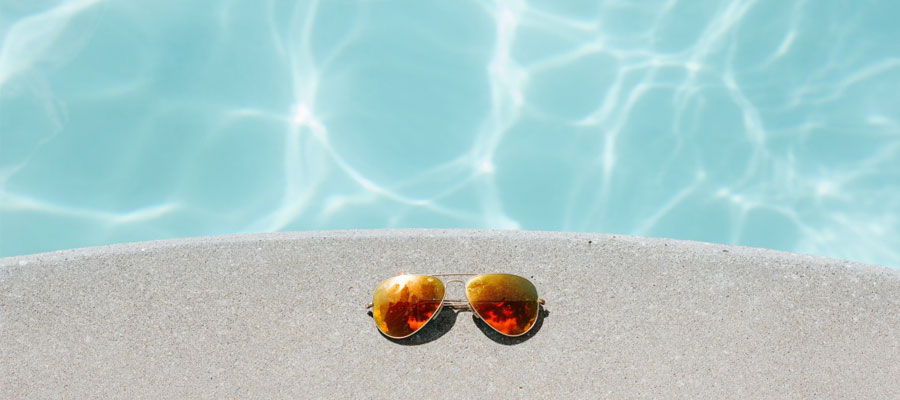 lunettes de soleil posées sur le bord de la piscine
